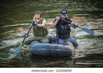 Female Special Forces Training In Landing Rubber Boat Moving Across The River. Firearm Shooting And Tactical Training.