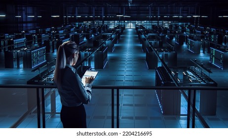 Female IT Specialist Uses Tablet In Data Center. Server Farm Cloud Computing Facility With Maintenance Administrator Working. Cyber Security Engineer Working In Personal Network Protection.