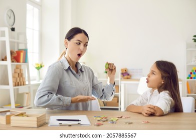 Female speech therapist curing child's problems and impediments. Happy kid together with homeschool mom or private English language tutor learning letter O, playing fun games and doing funny exercises