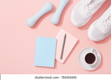 Female sports flat lay, dumbbells, notepad, sneakers on pink background, New Year fitness resolutions - Powered by Shutterstock