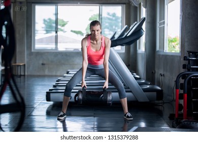 Female In Sportswear Lifting Heavy Bag While Exercising In Gym