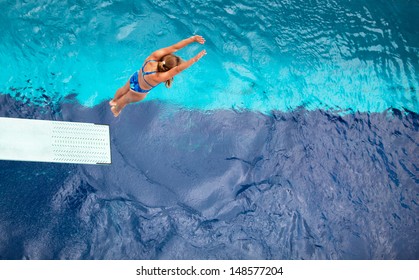 Female Springboard Diver Diving Into The Swimming Pool