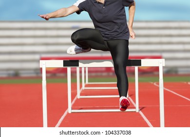 Female sprinter leaps over hurdle - Powered by Shutterstock