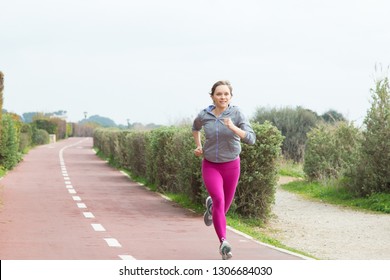 Female sprinter running fast on stadium track. Motivated female athlete participating in race. Runner concept - Powered by Shutterstock