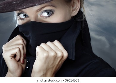 Female Spy In Hat With Face Covered By The Coat Collar