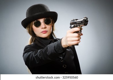 Female Spy With Weapon Against Gray