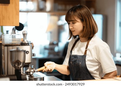 The female staff in the coffee shop works with a smile, professionally brewing coffee, pouring over coffee with hot water and filter paper in cafe. - Powered by Shutterstock