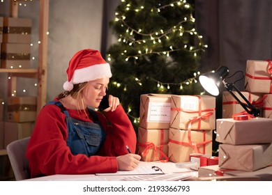 Female Startup Entrepreneur Small Business Owner Working At Home Night, Packaging And Delivery Situation. Communication With Client, Online Order On Mobile Phone. Christmas Sale. Start Up SME Concept