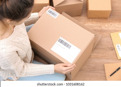 Female Startupper Preparing Parcels For Shipment To Customers Indoors