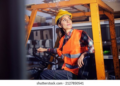 A female storage worker driving freight on forklift. - Powered by Shutterstock