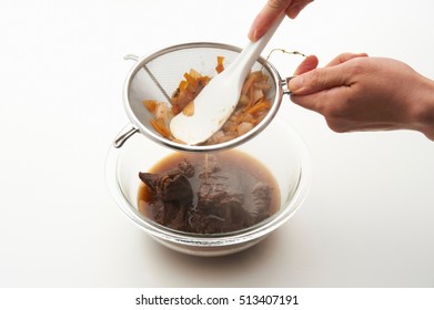 Female Straining Vegetable Stock From Sieve