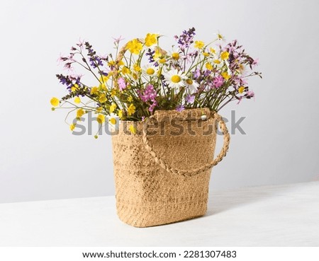 Female straw bag with wildflowers