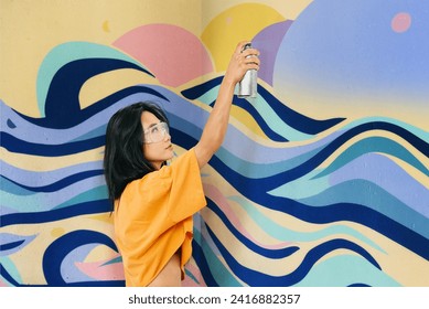 Female street artist painting bright colorful graffiti on wall Modern art, urban concept. Full length portrait - Powered by Shutterstock