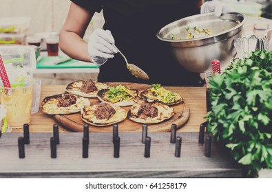 Female Street Vendor Hands In Gloves Make Taco Outdoors. Mexican Cuisine Snacks, Fast Food Of Commercial Kitchen.