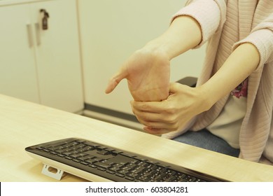 female stretch her fingers, hands and arms because of pain from office syndrome