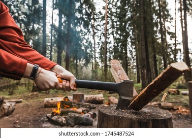 Female strong hands chop firewood with axe for bonfire. Powerful ax blow. Survival on camping trip. Harvesting wood in forest. Camp wild tourists. Splitting logs with sharp hatchet. Young woodcutter - Powered by Shutterstock