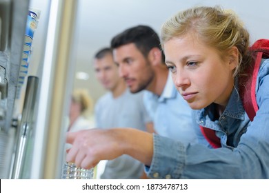 female student bending down to read notice board - Powered by Shutterstock