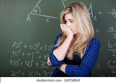 Female student deep thoughts standing at blackboard - Powered by Shutterstock