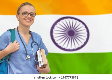 Female Student Doctor With Stethoscope And Books In Hand On The India Flag Background. Medical Education Concept. Medical Learning In India