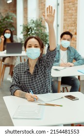 Female Student In Facial Mask Raising Hand For Answer