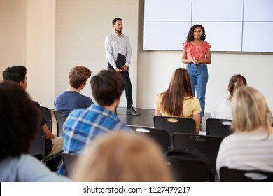 Female Student Giving Presentation To High School Class In Front Of Screen