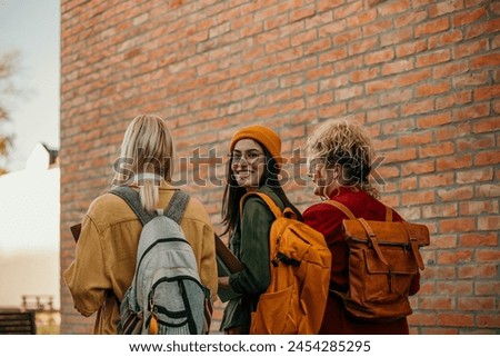 Female student glancing back while going to a class in college. Girl walking with friends going to class in college