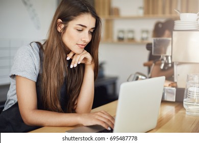 Female Student Having A Summer Job As A In Local Coffee House.