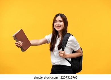 Female Student Holding The Books And Shoulder Bag On The Back While Smiling And Preparing For Studying In College Isolated Over Yellow Background.