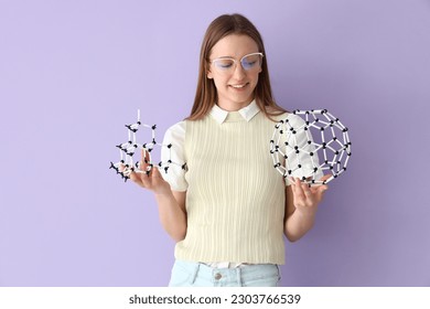 Female student with molecular models on lilac background - Powered by Shutterstock