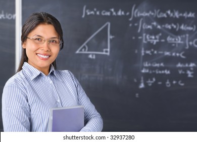 Female student pose in front of blackboard
