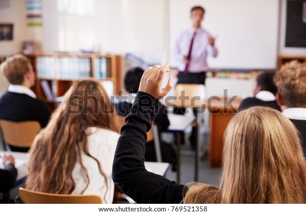 Female\
Student Raising Hand To Ask Question In\
Classroom