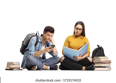 Female Student Reading A Book And Bored Male Student Looking At His Mobile Phone Isolated On White Background