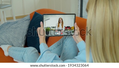 Female student study online and learns video lesson with teacher using tabletPC at home. E-learning classe, webinar, distance course or workshop concept at COVID-19 pandemic.