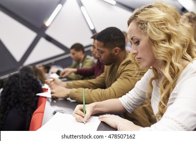 Female Student Taking Notes In A University Lecture Theatre