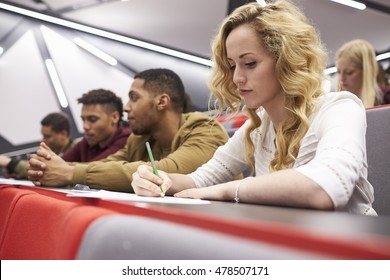 Female Student Taking Notes In A University Lecture Theatre