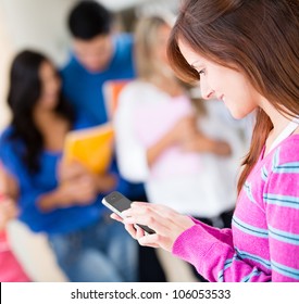 Female Student Texting On Her Mobile Phone