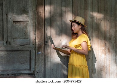 A Female Student Travels On A Community Field Trip And Holds A Laptop To Submit Reports Online. 