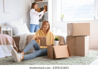 Female student unpacking things in dorm room on moving day - Powered by Shutterstock