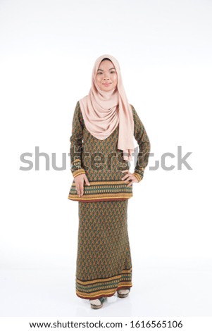 Female student wearing modern kurung with hijab, a modern urban lifestyle apparel for Muslim women isolated on white background. Beauty and hijab fashion concept.