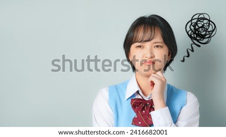 A female student wearing a uniform looking dissatisfied