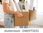 Female students with cardboard boxes in dorm room on moving day, closeup