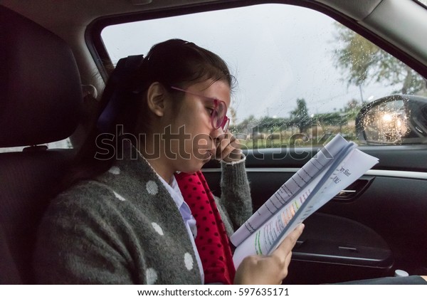 Female students are\
reading the document review before the exam in the car on the road\
at the traffic jam.