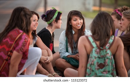 Female students talking outdoors on the sidewalk