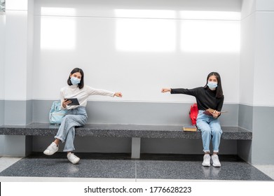 Female Students Wearing Masks, Sitting And Spaced Away Social Distancing At The University