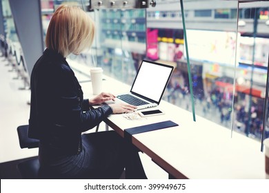 Female successful businesswoman is using for distance work laptop computer with empty copy screen for your advertising text message. Hipster girl is searching information on web page via net-book