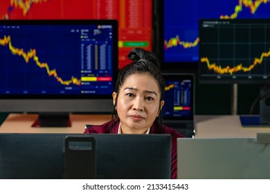 Female Successful Professional Trader Investor Sit Smile Look At Camera Surrounded By Computer Monitor Screen With Graph Chart Stock And Bitcoin Cryptocurrency Analysis Growth Report In Trading Room.