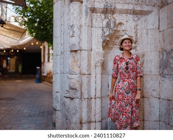 female summer travel to Antalya, Turkey. young asian woman in red dress walk through old town Kalechi , female tourist traveler discover interesting places and popular tourist attraction