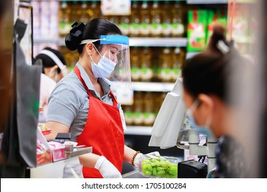Frau im Supermarkt Kassiererin in medizinischer Schutzmaske, die im Supermarkt arbeitet. Ausbruch der Covid-19-Ausbreitung  