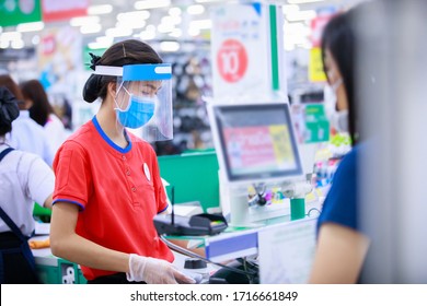 Female Supermarket Cashier In Medical Protective Mask And Face Shield Working In Grocery Store. Covid-19 Spreading Outbreak  