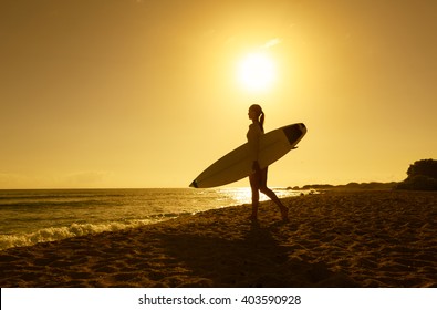 Female Surfer Walking On The Beach. 